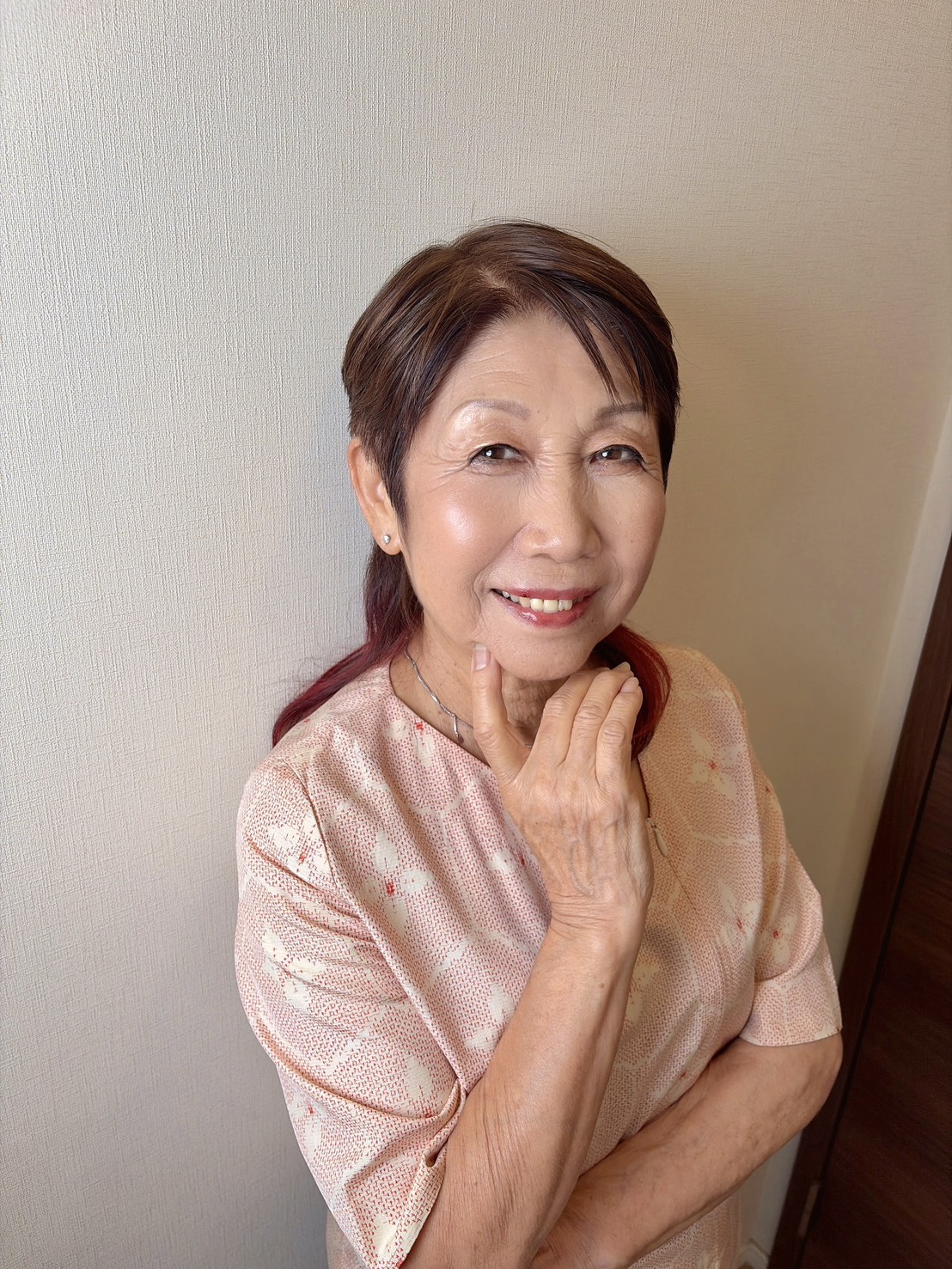 明るく華やかなメイクに仕上がり、頬に手を添えてほほえむなおさん